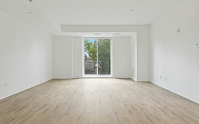 Pièce neuve et vide avec parquet clair et porte-fenêtre